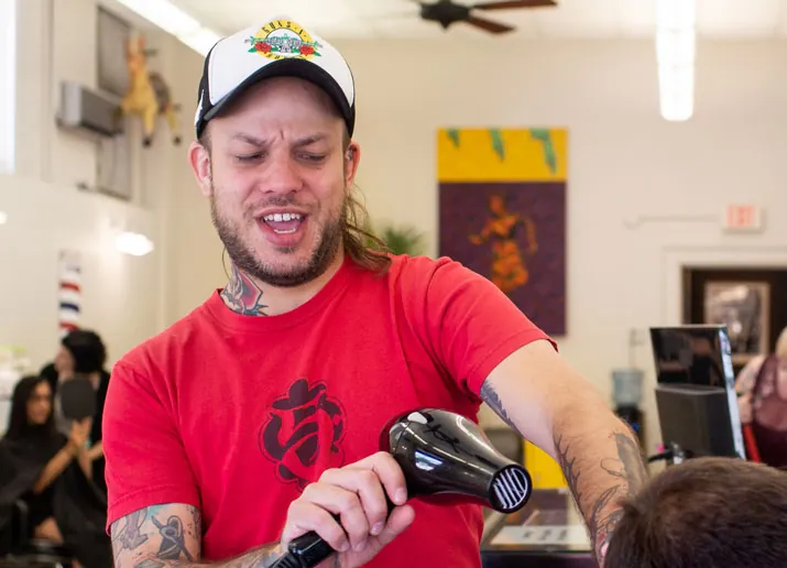 Brandon the barber holding a blow dryer